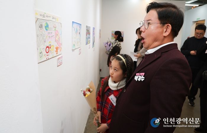 박강수 마포구청장이 수상 어린이와 함께 전시된 그림을 살펴보고 있다.