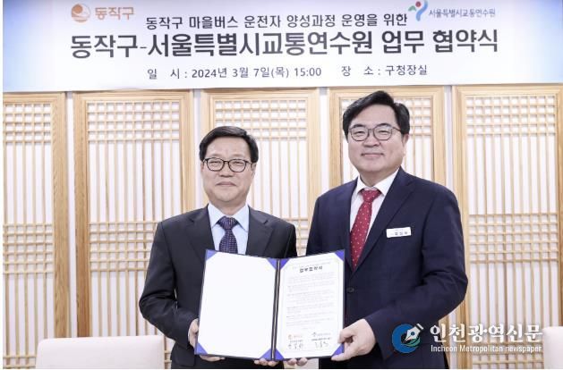 박일하 동작구청장(오른쪽)이 지난해 3월 고홍석 서울시 교통연수원장(왼쪽)과 업무협약을 체결한 후 기념 촬영하고 있다.