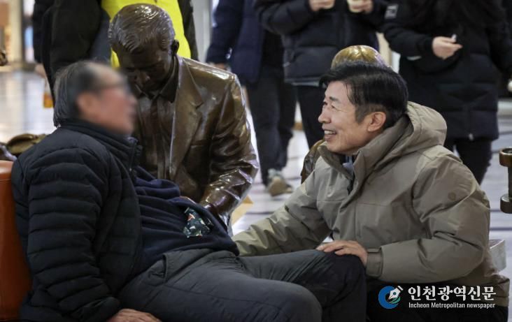 새해 첫날인 1일 고속터미널 대합실을 찾은 전성수 구청장(오른쪽)이 노숙인들의 안전을 확인하며 격려하고 있다.