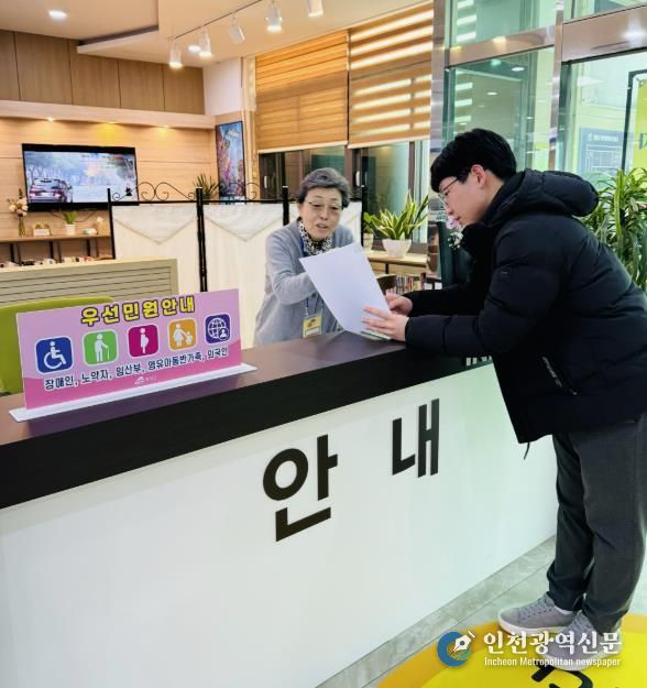 군 행복민원과를 방문한 민원인에게 어르신 민원안내 도우미가 안내를 하고 있다.