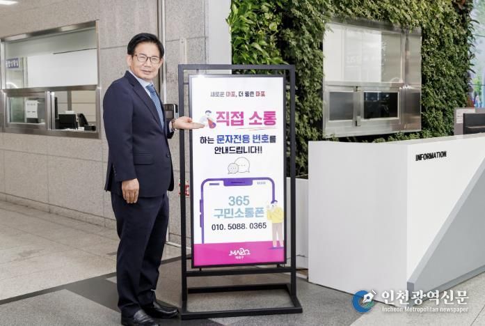 박강수 마포구청장이 365구민소통폰에 대해 안내하고 있다.