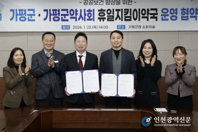 서태원 가평군수(사진 왼쪽에서 세번째)와 안병현 가평군약사회 회장(〃 네번째) 등이 22일 휴일지킴이약국 운영 협약식 후 협약서를 보이며 기념촬영을 하고 있다.