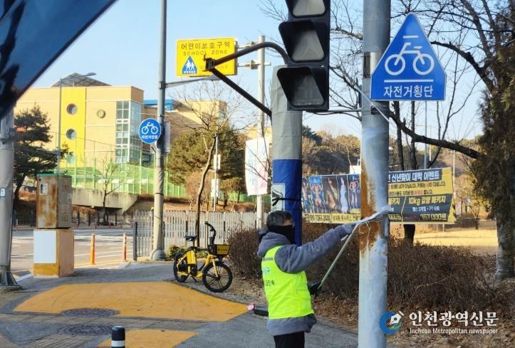 유성구청 직원이 어린이 보호구역 내의 불법광고물을 정비하고 있다