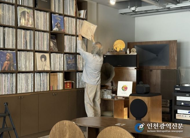 음악감상실 온 주인장이 신청곡 LP를 찾고 있다.