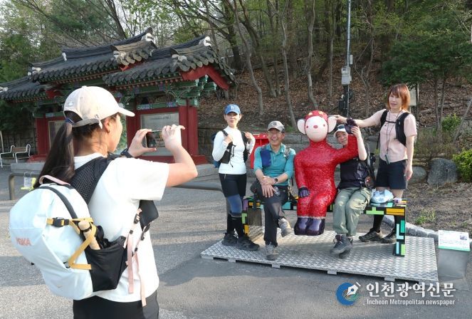 관악산 등산로 입구 으뜸공원에 설치된 작품 ‘하이’와 함께 기념사진을 촬영하는 등산객들